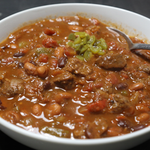 Cargar imagen en el visor de la galería, Bowl of chili with beans and vegetables on a dark surface