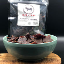Load image into Gallery viewer, Packaged beef jerky labeled 'Black Pepper & Sea Salt' displayed next to an bowl filled with the jerky pieces.